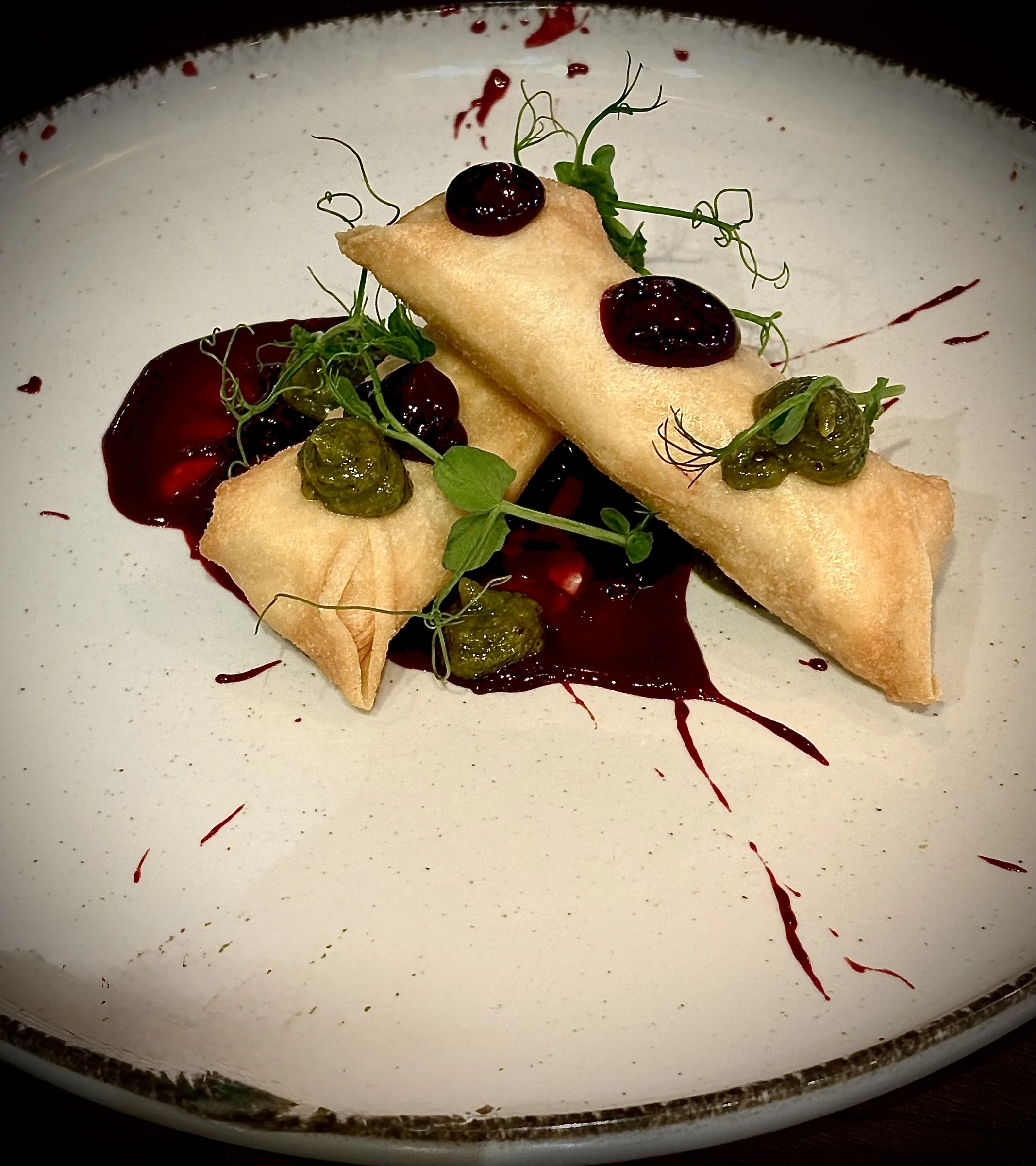 Crisp rolls plated with berry sauce and pesto