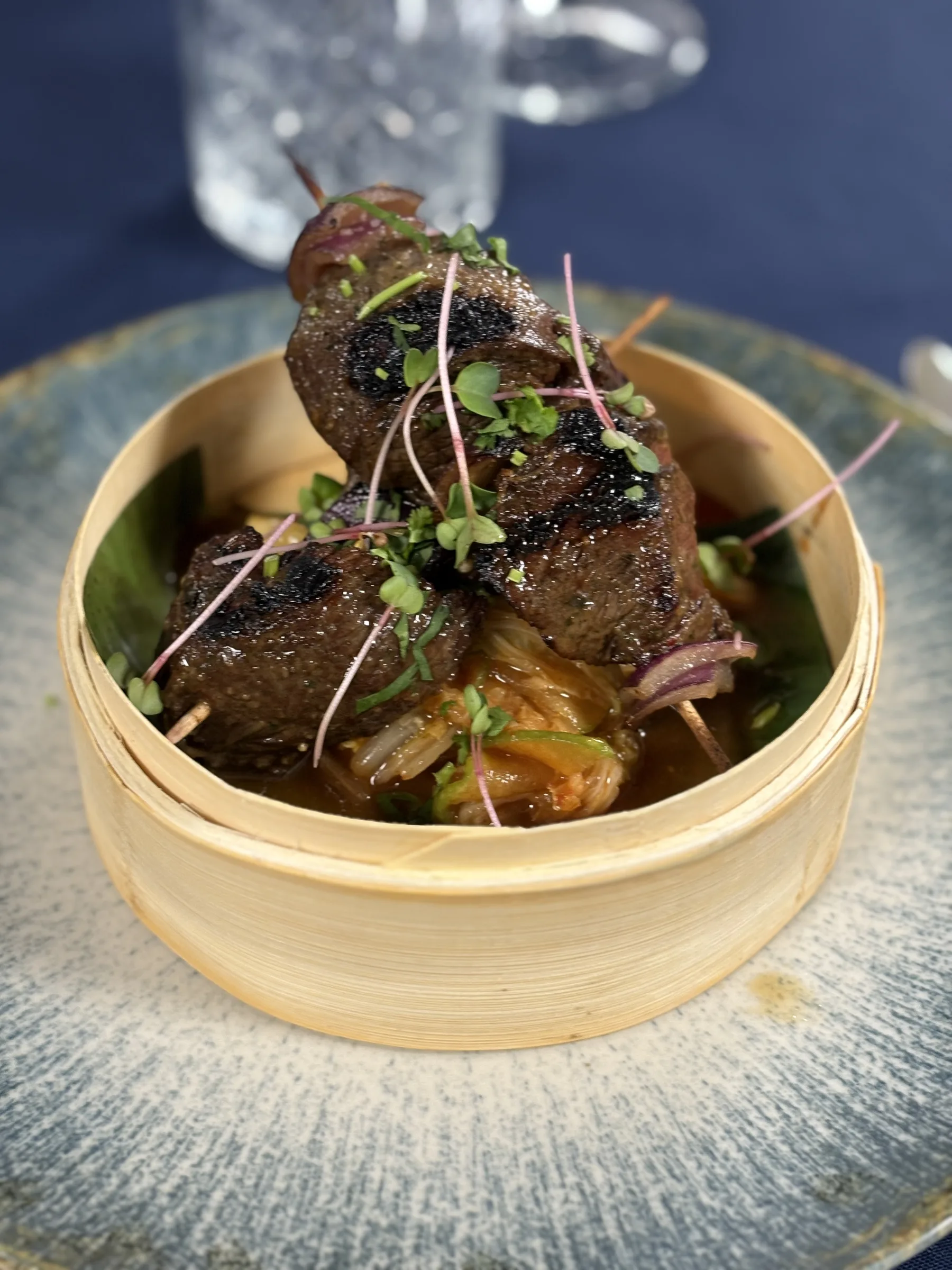 Grilled skewers served in a bamboo basket